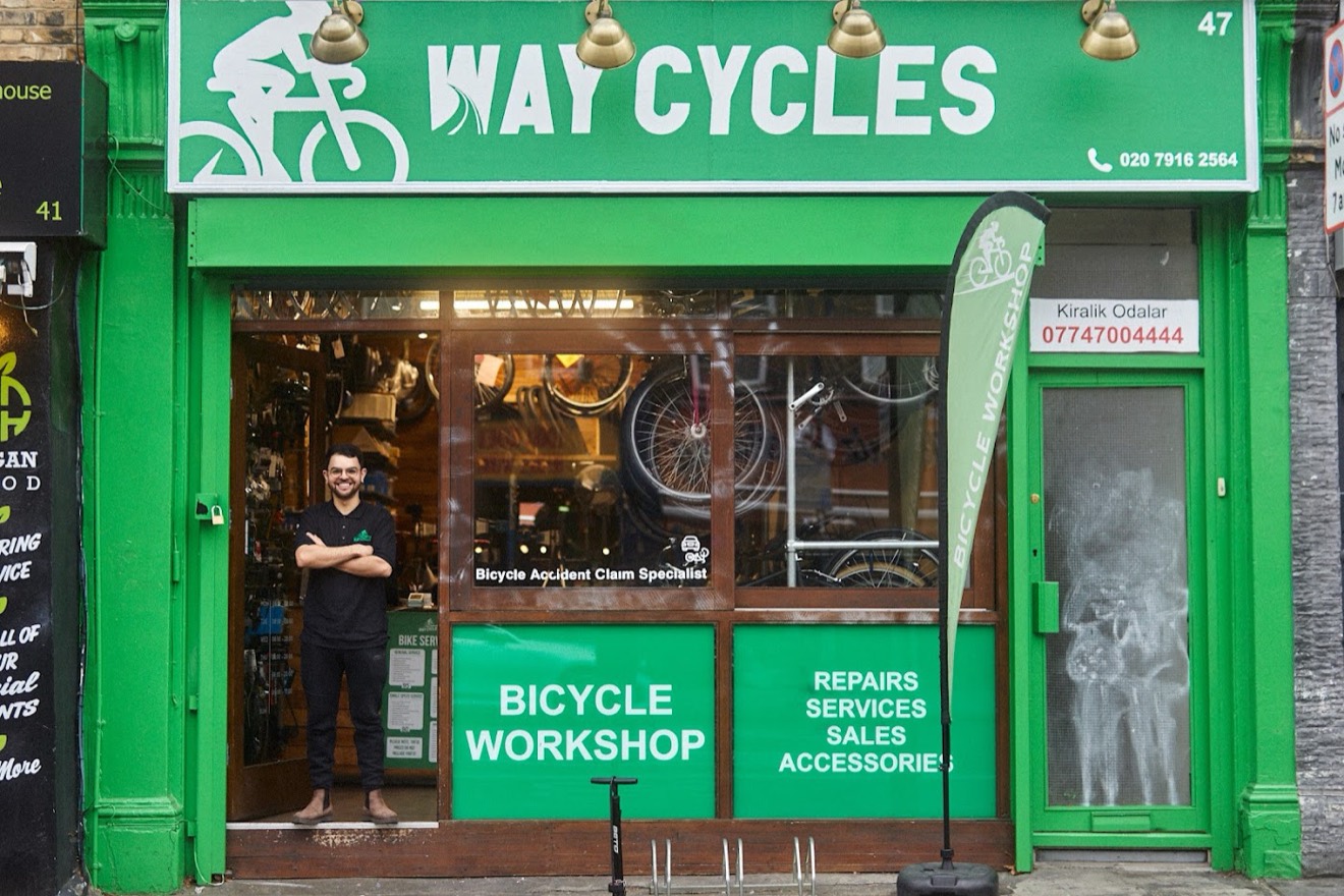 Way Cycles shopfront on Stoke Newington High Street, with a mechanic in the doorway